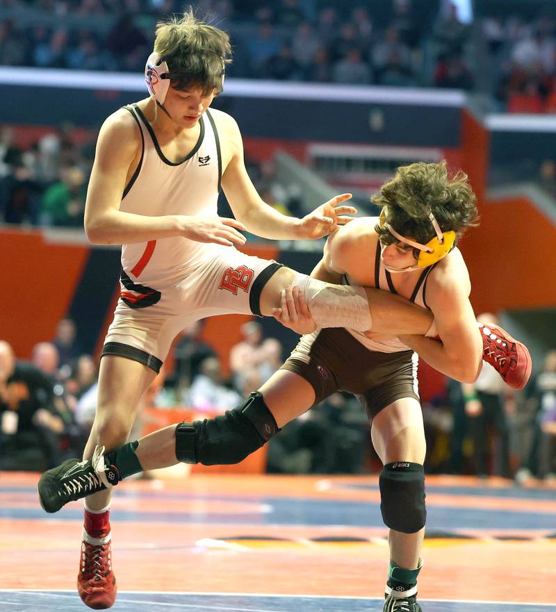 Jacobs’ Dominic Ducato (right) trips up Bradley-Bourbonnais’ Ethan Spacht during the Class 3A 113 pound 3rd place match in the IHSA individual state wrestling finals in the State Farm Center at the University of Illinois in Champaign.
