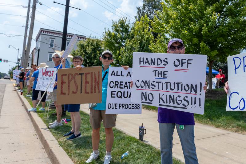 Protesters hold signs at the “No Kings” protest on Saturday,  August 9, 2025 at Rotary Park in Princeton.