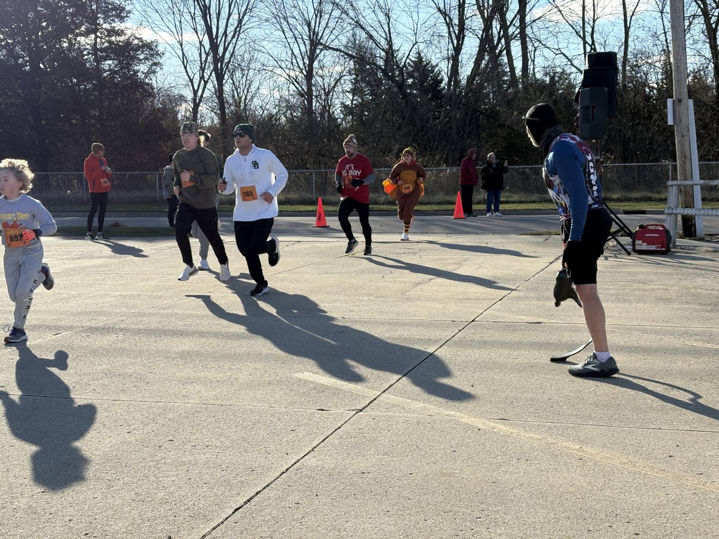 Tim Novak, known as “Juan Leg,” shouts encouragement at runners as they cross the finish line of the 47th annual Oglesby Turkey Trot, a tradition he has followed for 13 years.