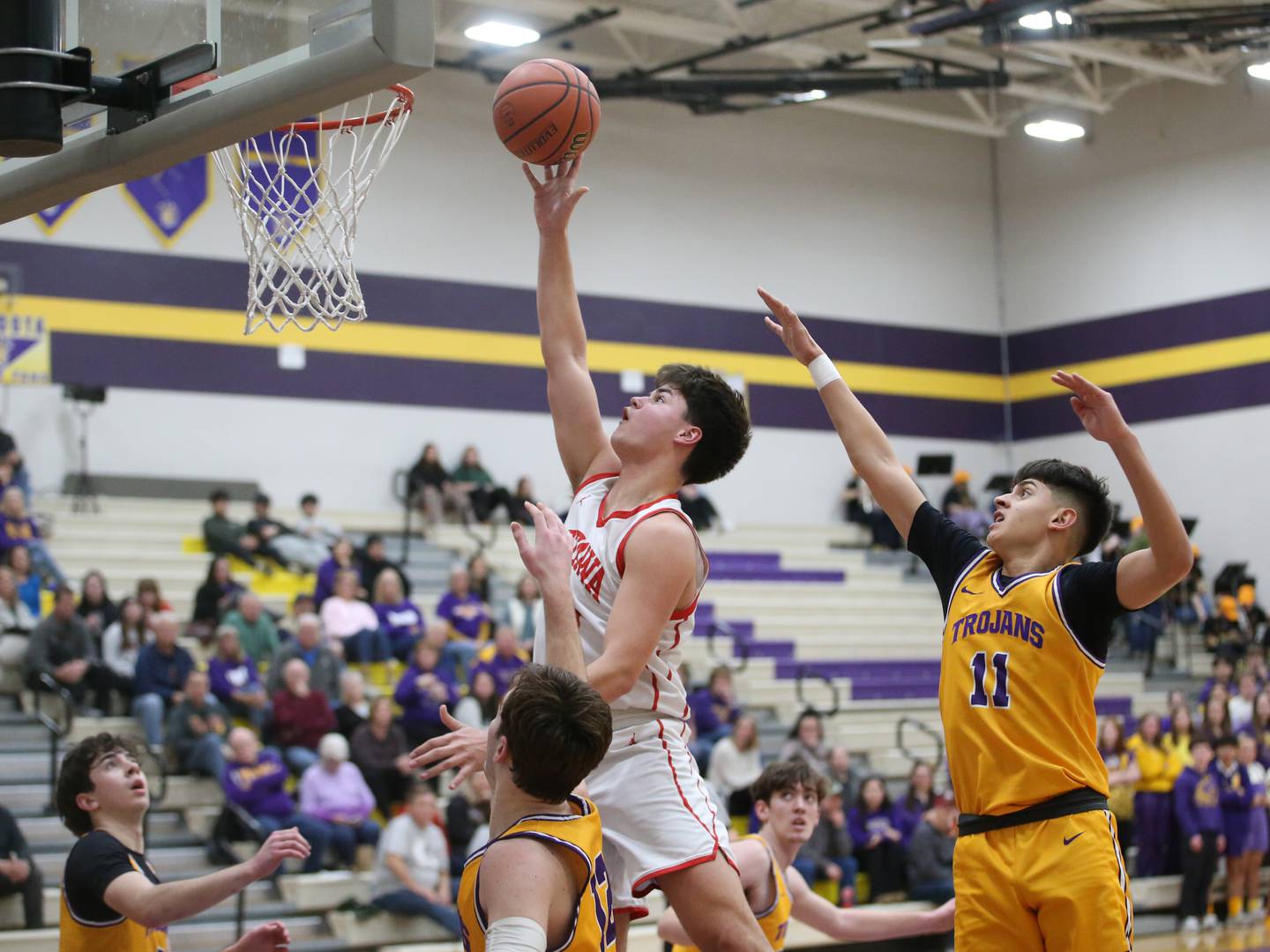 Ottawa's Cooper Knoll drives to the hoop as Mendota's Braiden Freeman and Iziah Nenez defend in February at Mendota High School.