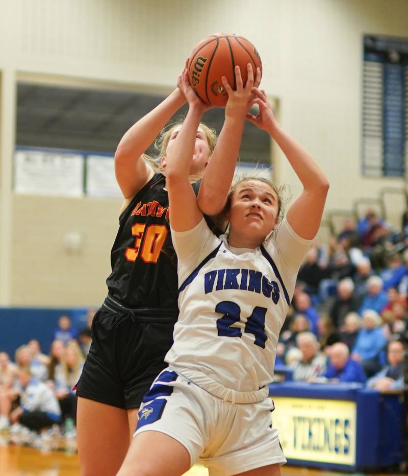 Batavia’s Reagan Sulaver (30) and Geneva’s Kinsey Gracey (24) fight for a rebound during a basketball game at Geneva High School on Friday, Dec 15, 2023.