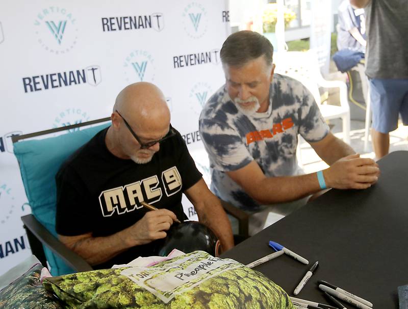 Ross Vehing of Crystal Lake talks with former Bears quarterback Jim McMahon as he signs autograph for him during the grand opening of the Vertical Dispensary on Saturday, Sept. 30, 2023, in Cary. The dispensary has been open for about a month.