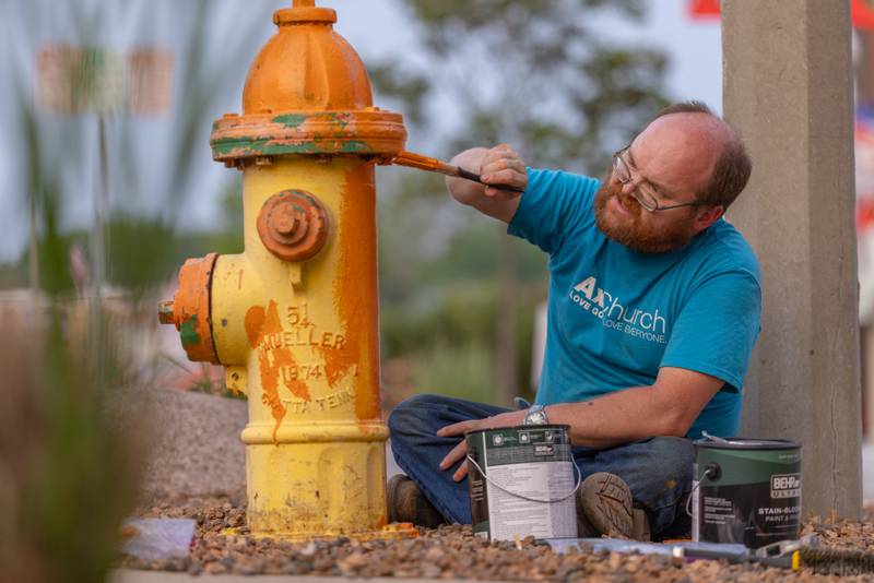 James Duncan applies paint to a fire hydrant as one of the projects for Hope Week on June 2, 2025 in Spring Valley.