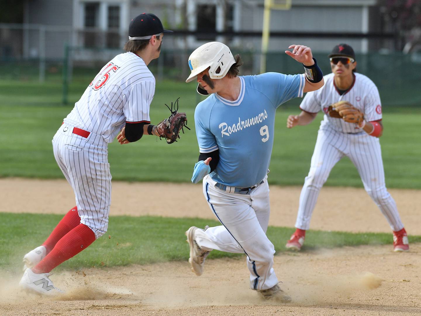 Nazareth's Nick Drtina (9) tries to dodge the tag of Benet's Cole Reifsteck. Drtina was able to stay in the rundown long enough for his teammate to score from third base before the final out of the inning during a game against Benet on April 22, 2024 at Benet Academy in Lisle.