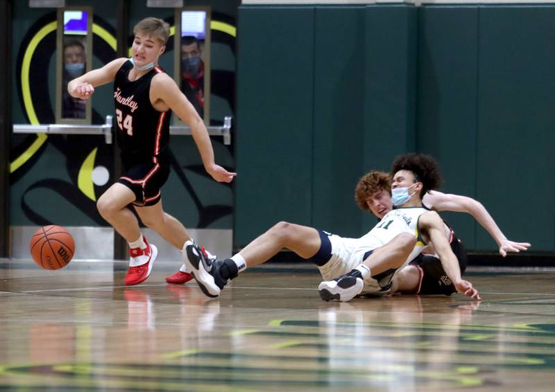 Huntley’s Aiden Wieczorek, left, scrambles after a collision between Crystal Lake South’s Isaiah Kirkeeng and Huntley’s Adam Guazzo knocked the ball loose in boys varsity basketball at Crystal Lake South Friday night.