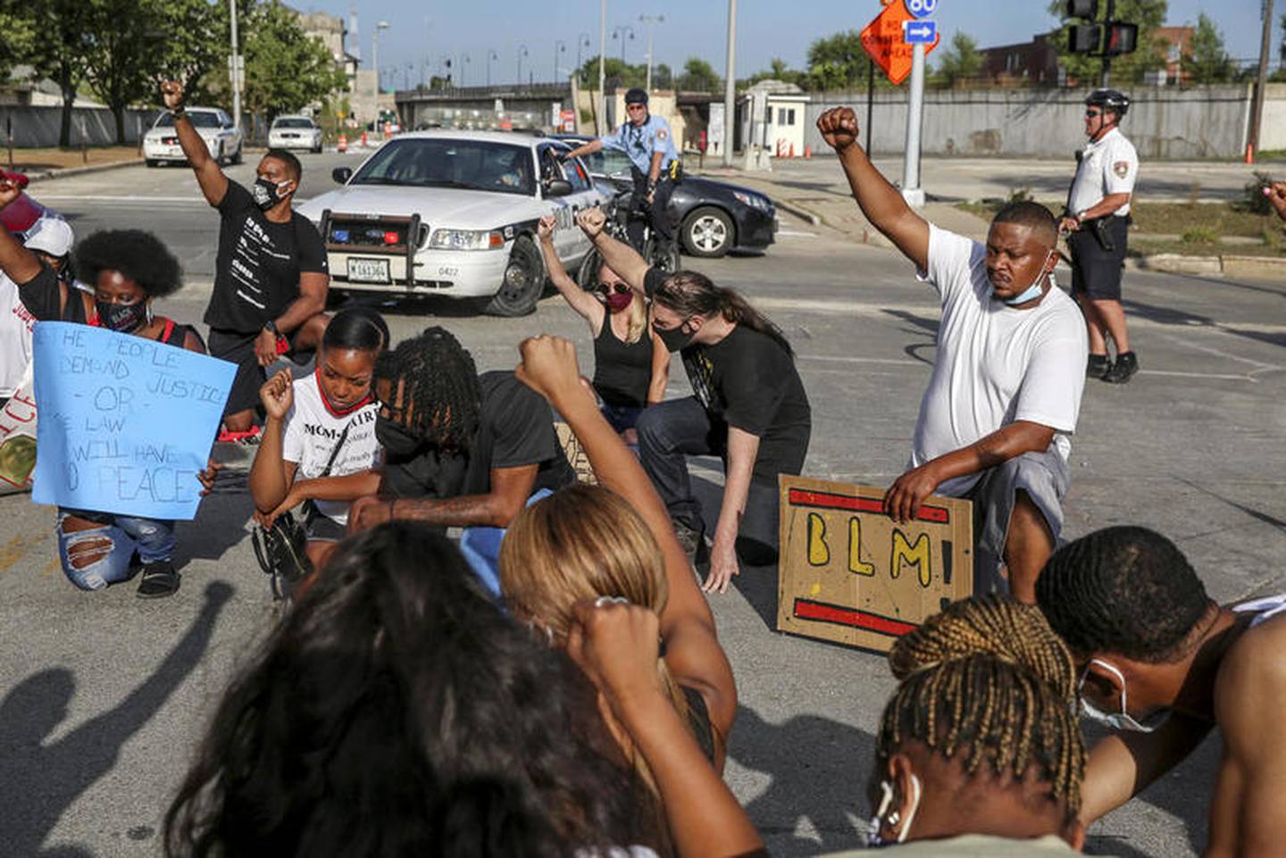 Demonstrators can be seen taking a knee during a moment of silence outside the Will County Courthouse on Saturday, Aug. 22, 2020, in response to the January 28 overdose death of Eric Lurry who died in police custody.
