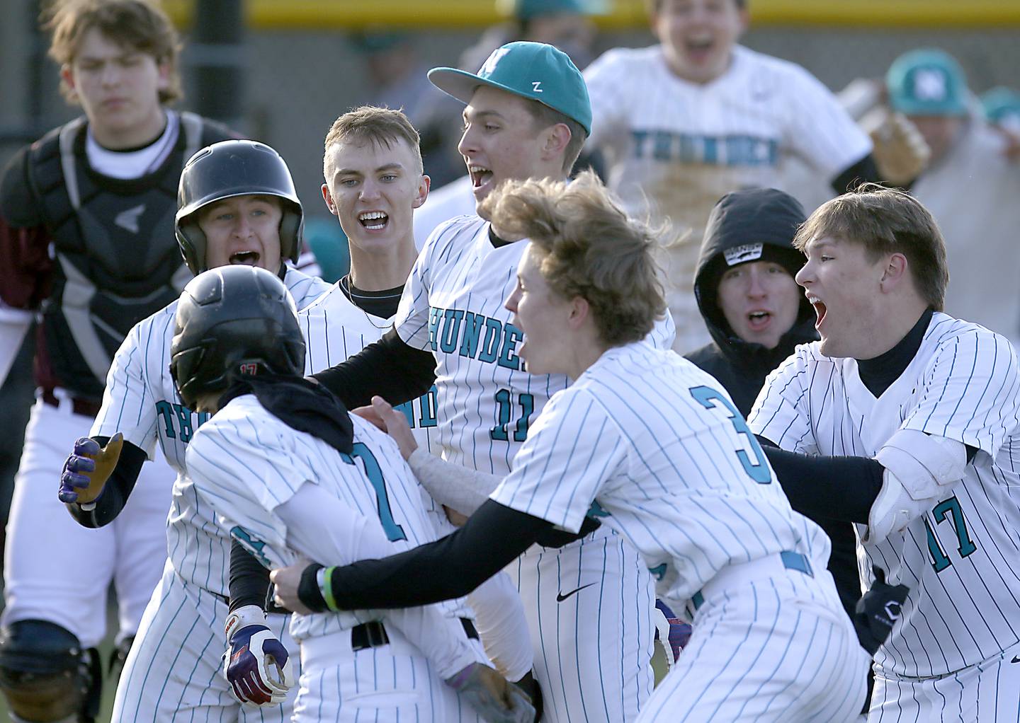 Woodstock North’s Morgan Klinker is mugged by his teammates after Klinker scored the winning run during a Kishwaukee River Conference baseball game against Marengo Wednesday, April 25, 2023, at Woodstock North High School.