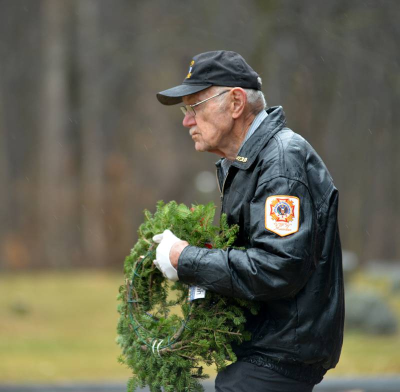 Oregon VFW member and Korean War veteran Stan Eden of Oregon, carries a military division wreath at the start of he Wreaths Across America event at Daysville Cemetery. east of Oregon, on Saturday, Dec. 16, 2023.