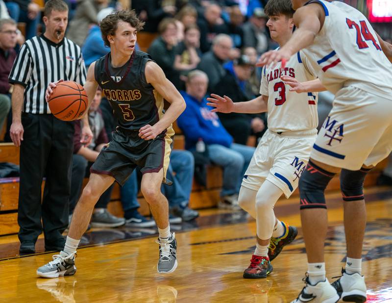 Morris’ Caston Norris (5) plays the ball on the wing against Marmion's Collin Wainscott (3) and Trevon Roots (24) during the 59th Annual Plano Christmas Classic basketball tournament at Plano High School on Tuesday, Dec 27, 2022.