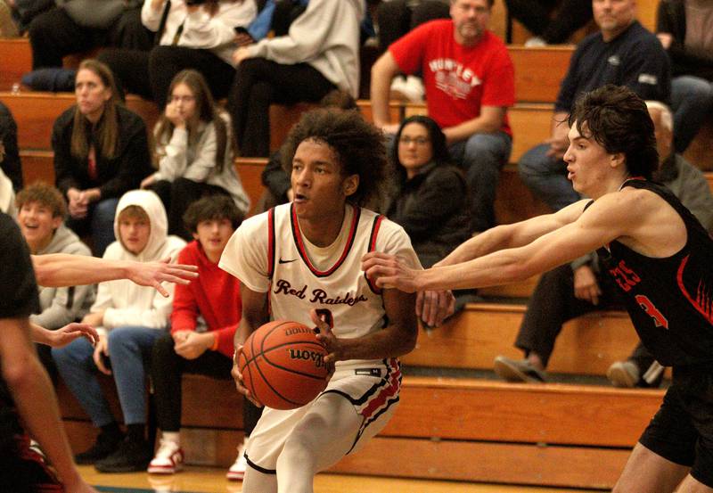 Huntley’s Omare Segarra, center, slips past Crystal Lake Central’s Jackson Hopkins during tournament basketball action at Johnsburg High School Monday evening.