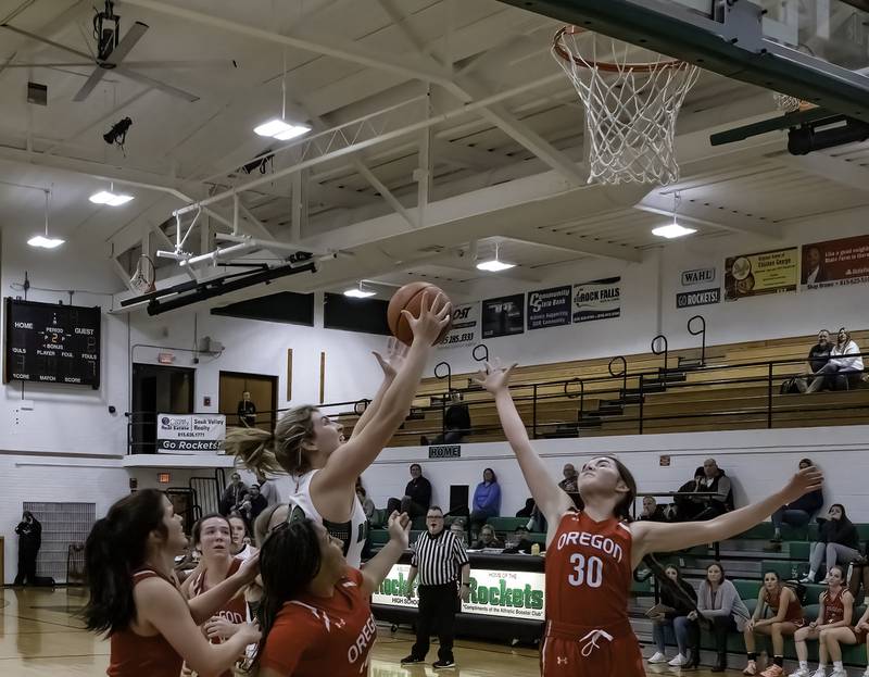 Rock Falls' Claire Bickett (top) grabs a rebound between Oregon's Mariah Drake and Mya Engelkes (right) during their Big Northern Conference game Friday night at Tabor Gym.