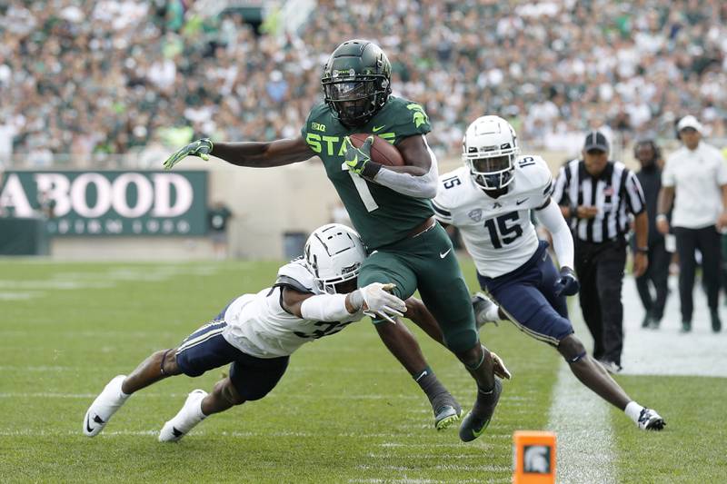 Michigan State's Jayden Reed, center, is pushed out of bounds by Akron's Devonte Golden-Nelson, left, as Akron's KJ Martin, right, trails the play during the first quarter of an NCAA college football game, Saturday, Sept. 10, 2022, in East Lansing, Mich. (AP Photo/Al Goldis)