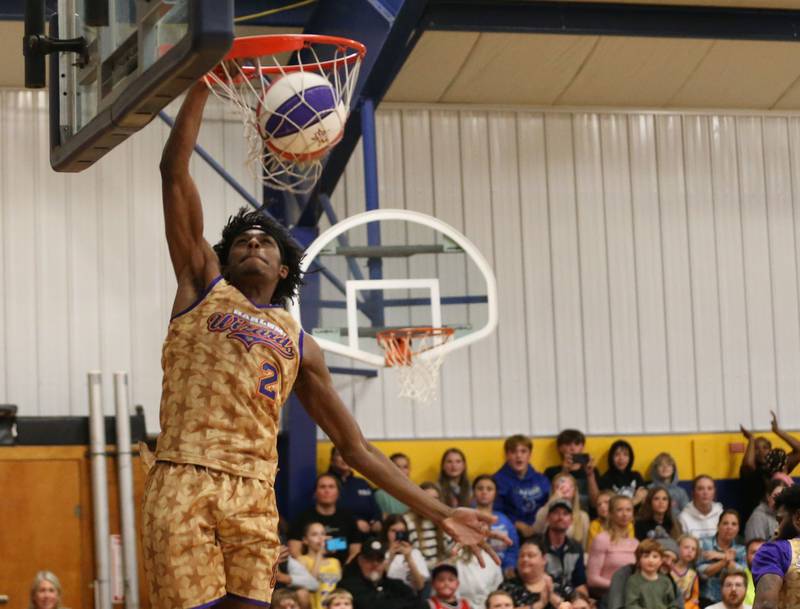 Harlem Wizards player Devale Johnson ,(Too Tall) dunks the ball during the Harlem Wizards event on Tuesday, Oct. 28, 2025 in Pannebaker Gymnasium at Logan Jr. High School in Princeton.