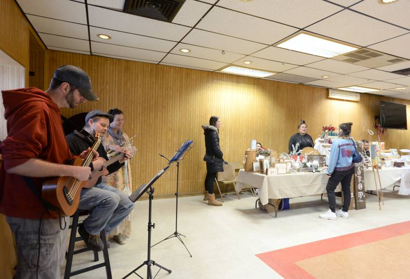 (left-right) Will Ash, Mike Belc and Chrissy Ash of St. Charles entertain shoppers with Christmas songs during the Holiday Pop-Up Market in Berwyn Saturday Dec 10, 2022.