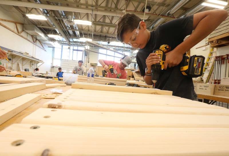 Students Cale Full and Geno Agrubright use drills to screw into boards while making a Adirondack chair during the Area Career Center Hands-On Showcase on Thursday, June 8, 2023 at La Salle-Peru Township High School.