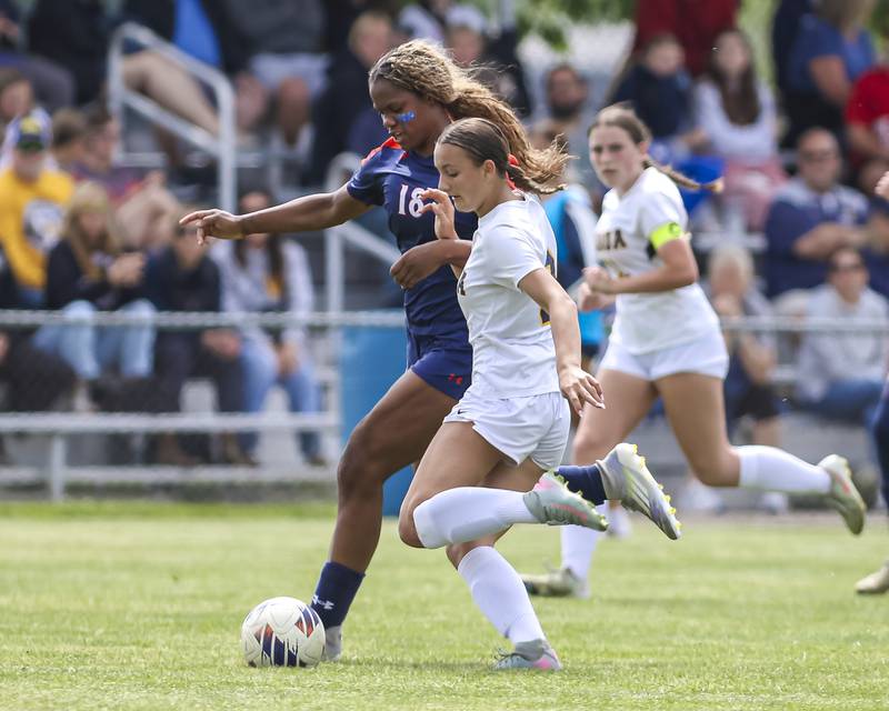 Oswego's Jordyn Washington (18) chases down the ball while fending off Neuqua Valley's Sarah Shannon (9) during Class 3A regional final soccer match between Neuqua Valley at Oswego on Saturday, May 23, 2026 in Oswego.