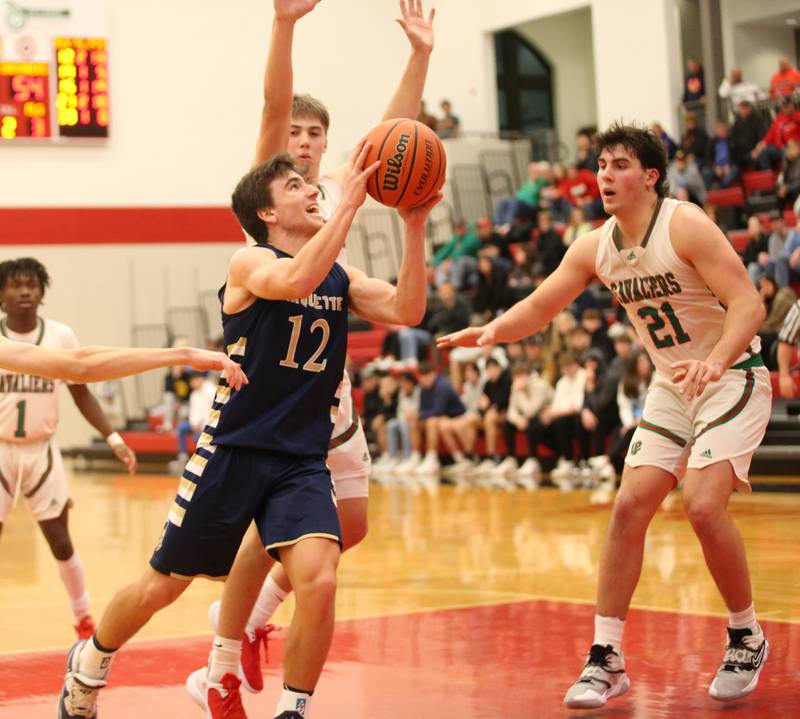 Marquette's Denver Trainor eyes the hoop while running in the lane past L-P's Seth Adams and teammate Josh Senica during the 49th annual Colmone Classic Tournament on Wednesday, Dec. 6, 2023 at Hall High School.