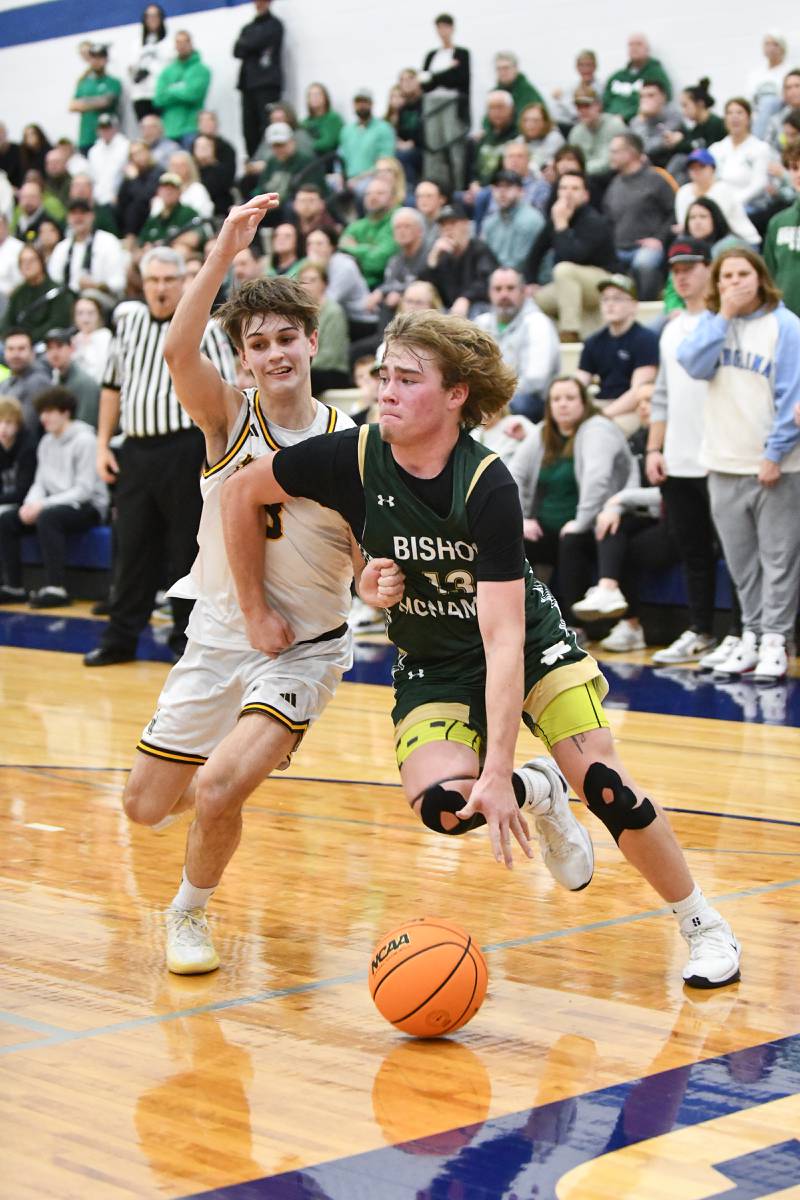 Bishop McNamara's Trey Provost drives to the lane against Joliet Catholic Academy's Connor Louthan during the Fightin' Irish's 79-67 victory over the Hilltoppers in the IHSA Class 2A Peotone Sectional semifinal on March 4, 2025.