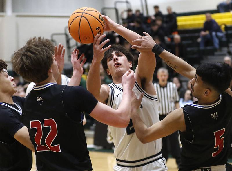 Cary-Grove's Brady Elbert (center) tries to grab a rebound between Marmion's Colin McEniry (left) and Ali Tharwani (right) during an IHSA Class 3A Crystal Lake South Regional boys basketball semifinal game on Wednesday, February, 25, 2026, at Crystal Lake South High School.