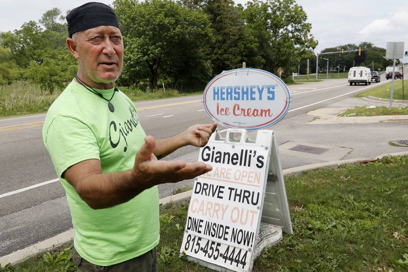 Terry Trobiani, fiancé of Gianelli's owner Debi Petersen, shows an A-frame style sign standing a few feet from the restaurant's entrance on Rt 176 on Tuesday, July 13, 2021 in Prairie Grove.  A village ordinance allows for one sign per business and restricts the types of signs displayed.