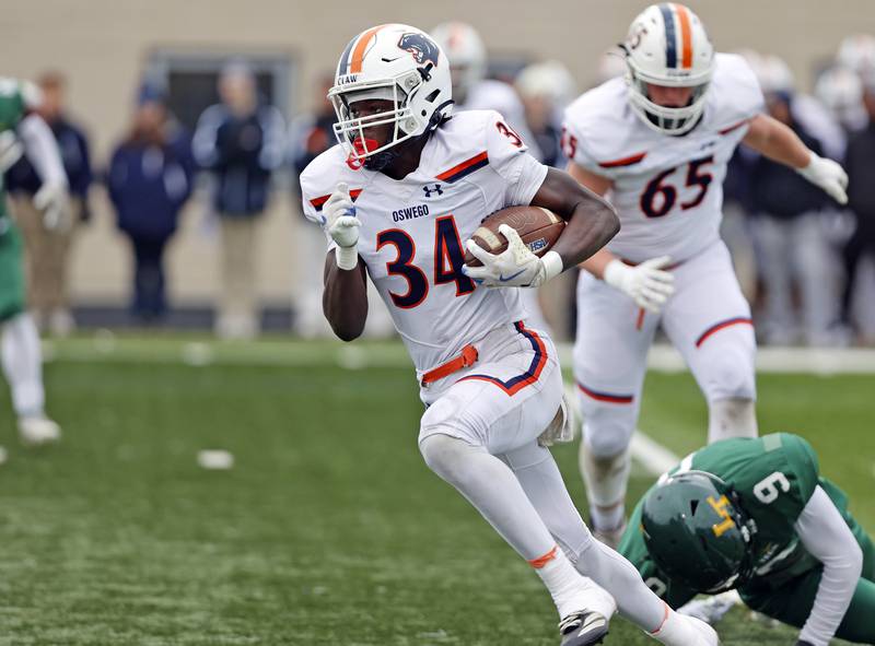 Oswego's Ammar Banire (34) runs with the ball during the varsity football second-round 8A playoff game between Oswego and Lane Tech on Saturday, Nov. 8, 2025 in Chicago.
