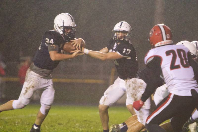 Cary Grove's Jameson Sheehan hands the ball off to Nicholas Hissong at the Class 6A First Round Playoff on Friday, Oct. 29,2021.