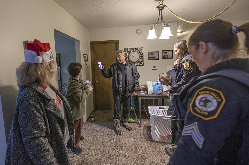 Shields family guardian Kevin puts his wife on FaceTime to thank the Rock Falls officers Monday, Dec. 22, 2025, for the delivery of gifts for Operation Santa.