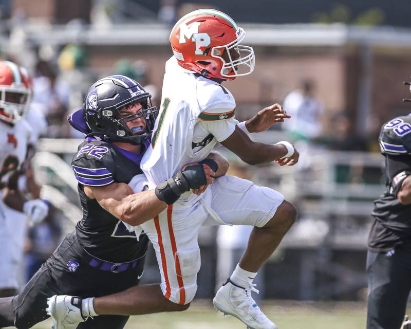 Downers Grove North's Joe Lasota (22) hits Morgan Park's Ronald Smith Jr. (1) as he releases the ball during football game between Downers Grove North at Morgan Park Saturday, Aug 30, 2025  in Chicago.