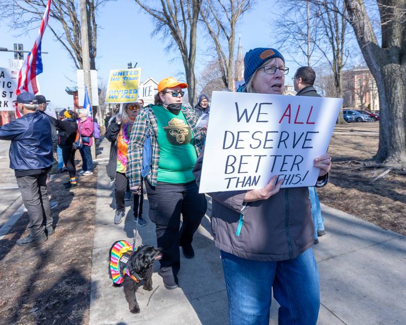 Protesters march down sidewalk at the 'Pretti good time for a Protest' on Feb. 15, 2026 at Washington Square Park in Ottawa.