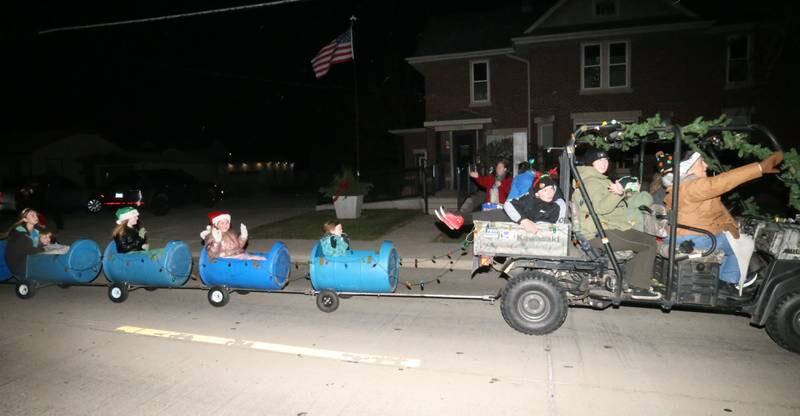 Kids ride barrels during the annual Christmas Parade on Saturday, Dec. 7, 2024 on Peoria Street in Peru.