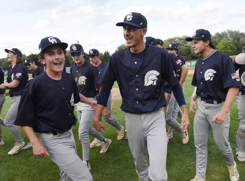 Cary-Grove starting pitcher Charlie Taczy, middle, celebrates with his teammates after the Trojans defeated St. Patrick 9-2 during the Class 3A supersectional baseball game at Wintrust Field on Monday, June 9, 2025 in Schaumburg.