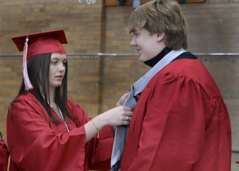 Upon arriving at Streator High School, the preparations before the graduation ceremony Sunday, May 22, 2022, begin as Aiden Yuhas receives some help with his tie from Mallory Goerne.
