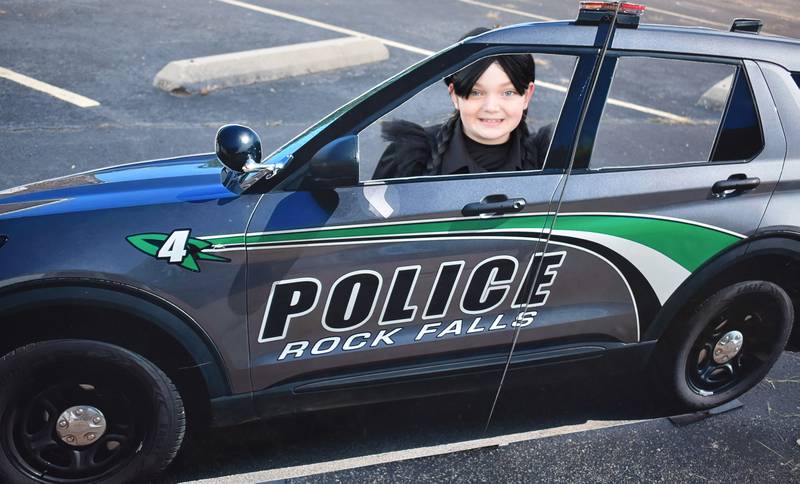 Lillian Dornbush, 9, from Rock Falls, poses in the Rock Falls Police Department cut-out car on Friday, Oct. 24, 2025, during the Biz Boo! Halloween event.
