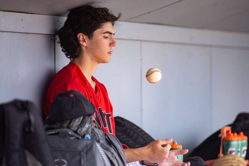 Benet Academy pitcher Gino Zagorac tosses a ball around in the dugout during a game against St. Francis High School during the Class 3A Kaneland Sectional final at Kaneland High School in Maple Park on Saturday, June 7, 2025.