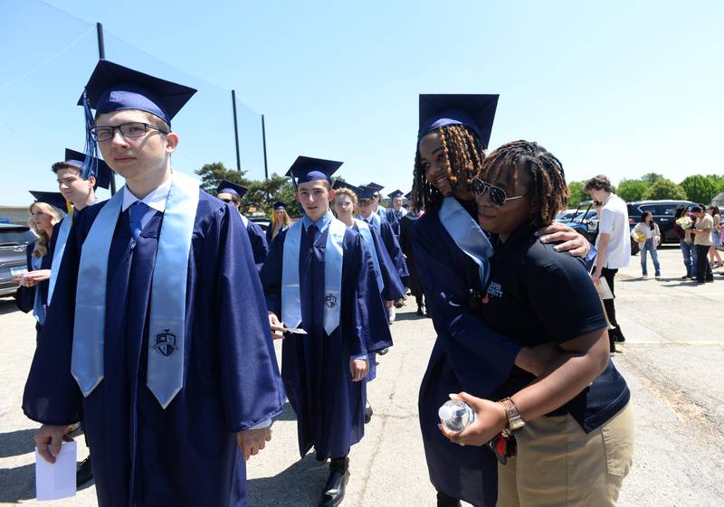 Downers Grove South security Alice Freelon hugs students including Clifton Neal during the graduation ceremony Sunday May 21, 2023.