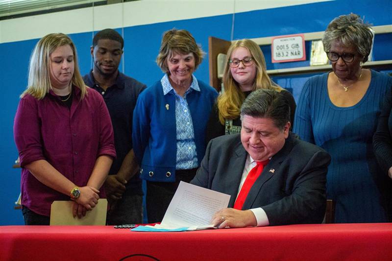 Gov. JB Pritzker signs a package of bills aiming to alleviate the state’s teacher shortage Wednesday at an event at Springfield High School.
