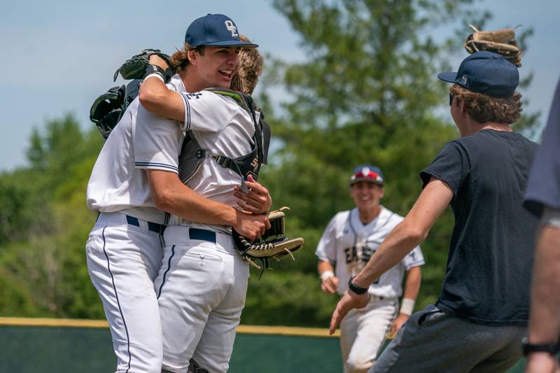 Oswego East's Griffin Sleyko (left) hugs East's Eric Lewis (2) after defeating Waubonsie Valley to win the Class 4A Waubonsie Valley Regional final at Waubonsie Valley High School in Aurora on Saturday, May 27, 2023.