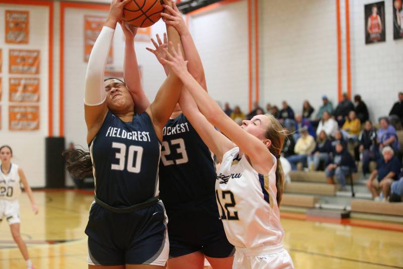 Fieldcrest's Aliah Celis and teammate Riley Burton grab a rebound over Marquette's Lilly Craig during the Integrated Seed Lady falcon Basketball Classic tournament on Monday, Nov. 13, 2023 at Flanagan High School.