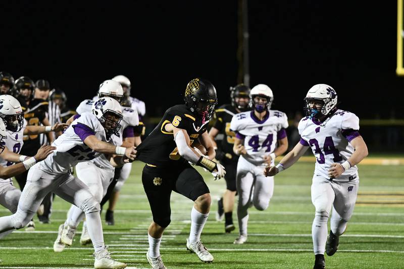 Reed-Custer’s Lucas Foote escapes the grips of Wilmington defenders for a first down Friday, Sept. 30, 2022, during the Comets’ win over the host Wildcats.