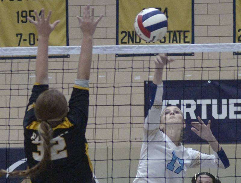 Marquette’s Avery Durdan sets to attempt a spick while Putnam County’s Maggie Spratt set to block  in the 1st set Thursday at Marquette.