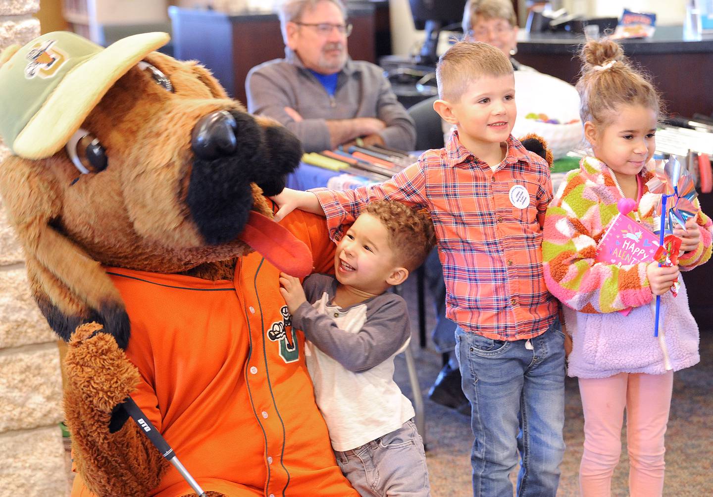 While David and Brie Yearwood of Yorkville pose for a picture, their friend Tucker Rader rough houses with "Spikes", the Joliet JackHammers' mascot during the Friends of the Yorkville Library's annual Mini Golf FUN Raiser on Sunday Feb. 5, 2023.