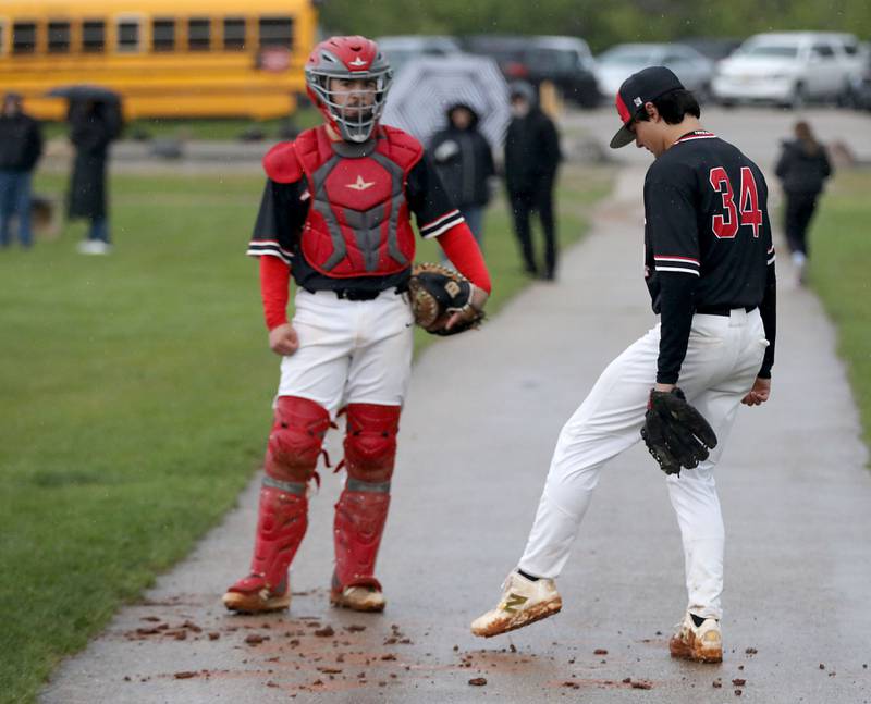 Huntley's Sean Dabe, (right) tries to get the mud out of his cleats during a Fox Valley Conference baseball game against Prairie Ridge on Friday, May 1, 2026, at Prairie Ridge High School.