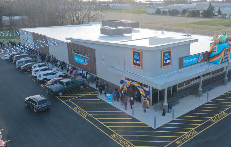 Hundreds of people wait in line to enter the new Aldi grocery store on Thursday, Nov. 13, 2025 at the corner of Backbone Road and North Main Street  in Princeton. The 12,000 square feet store began construction in May of this year. The first 100 people in line were given a chance to win a golden ticket to win a $100 gift card. Hundreds of people waited in line for free gift bags. The store hours are 9a.m.-8p.m. daily.