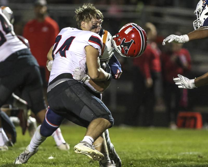 Yorkville's Gavin Geegan (34) loses his helmet while being tackled by Oswego's Conor Tully (40) during football game between Yorkville at Oswego Friday, Sept 26, 2025 in Oswego.