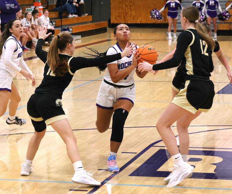 Rochelle's Carmela Bright splits two Sycamore defenders Friday, Dec. 5, 2025, during their game at Rochelle High School.
