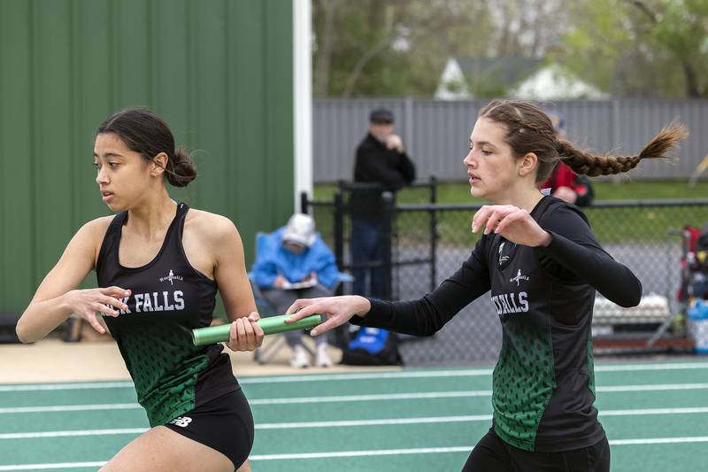Rock Falls’ Brenna Burlack takes the baton from teammate Ashley Rodriguez in the 4x800 Friday, April 25, 2025, during the Rock Falls Rocket Invite.