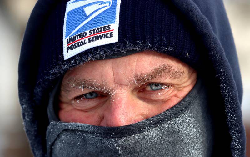 Frost on his nose and eyelashes, carrier Mike Driver of the United States Postal Service is bundled up as he makes deliveries along Washington Street in Marengo on Friday.