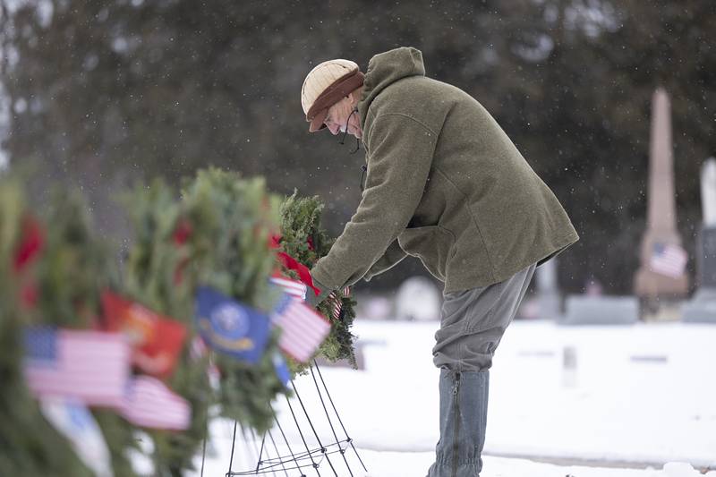 Gary Burrs places the final wreath Saturday, Dec. 13, recognizing the unknown soldiers who died for the United States. After placing nine wreaths representing the branches of the armed forces and other important groups of veterans, volunteers spread out to place wreaths on 92 headstones of veterans interred at Palmyra Cemetery.