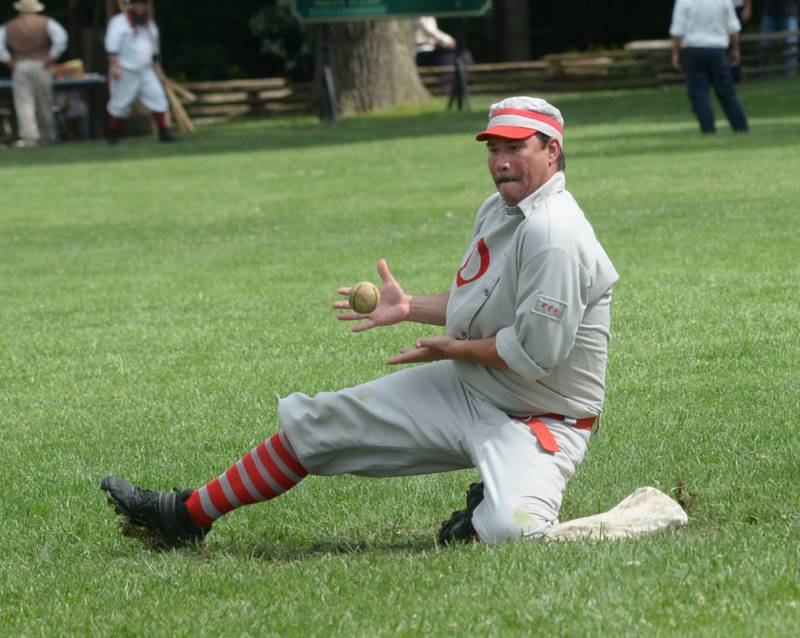 Ganymede's Justin Early slides to catch a throw against Flat Rock on Saturday, Aug. 12, 2023 at the 20th Annual World Tournament of Historic Base Ball.