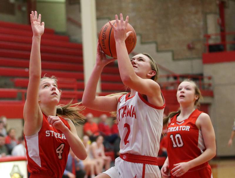 Ottawa's Ashlynn Ganiere eyes the hoop while running between Streator defenders Joey Puetz and Ava Gwaltney during the Lady Pirate Holiday Tournament on Wednesday, Dec. 20, 2023 in Kingman Gym.